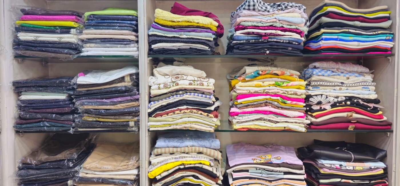 Folded western wear and casual tops arranged on glass shelving